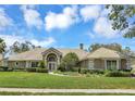 Beautiful home with a manicured lawn, arched entryway, and meticulously maintained landscaping at 8623 Summerville Pl, Orlando, FL 32819