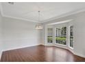Inviting living room boasting wood-look tile flooring, neutral paint, and a bay window overlooking the landscape at 8623 Summerville Pl, Orlando, FL 32819