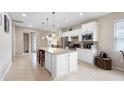 Bright kitchen features a large island, stainless appliances and white cabinetry at 1028 Salamanca Pl, Davenport, FL 33837