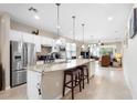 Open kitchen with stainless steel appliances, granite countertops, and a large center island with seating at 1028 Salamanca Pl, Davenport, FL 33837