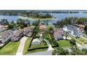 Aerial view showcasing a lakefront home with manicured lawns, mature trees, and a private dock at 11018 Lake Butler Blvd, Windermere, FL 34786