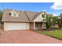 An inviting single-Gathering home with a brick driveway, lush lawn, and stylish architectural details at 1135 Thunder Trl, Maitland, FL 32751