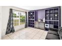 Bright and airy living room featuring stylish shelving, a comfortable couch, and a large window at 1221 N Brickell Dr, Deltona, FL 32725