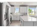Modern kitchen with white cabinetry, stainless steel appliances, and a center island with seating, open to dining area at 1811 Spring Shower Cir, Kissimmee, FL 34744