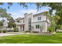 Attractive modern two-story house with white stucco, stone accents, and lush green lawn at 1820 Englewood Rd, Winter Park, FL 32789