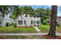 A charming home with a stucco exterior, red trim, inviting landscaping, and a tidy front yard at 2021 University Dr, Orlando, FL 32804