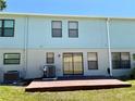 The rear exterior of the townhome features a small patio with a sliding glass door and green lawn at 2120 Windsor Lake Cir, Sanford, FL 32773