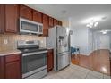 Well-equipped kitchen featuring stainless steel appliances, dark cabinets, and tiled flooring at 2120 Windsor Lake Cir, Sanford, FL 32773
