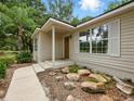 Inviting single-story home with a covered entry and rocks in the landscaping at 2193 County Road 204, Oxford, FL 34484