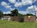 View of a street with a wooden fence and a glimpse of nearby residences under a sunny sky at 2223 Kilmer Ln, Apopka, FL 32703