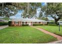 Beautiful brick home with lush green lawn, mature trees, and a brick walkway leading to the entrance at 2500 Lake Shore Dr, Orlando, FL 32803
