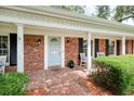 Welcoming front porch with brick flooring, white columns, and a light blue front door with glass detailing at 2500 Lake Shore Dr, Orlando, FL 32803