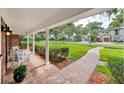 Covered front porch with brick flooring, white columns, seating, and a walkway to the street at 2500 Lake Shore Dr, Orlando, FL 32803