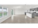 Open concept living room featuring tile flooring, abundant natural light, and a view of the modern kitchen at 2644 Hancock Crossing Dr, Bartow, FL 33830