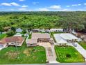 An aerial view shows the house, waterfront access, and lush surrounding landscape at 27714 Lois Dr, Tavares, FL 32778