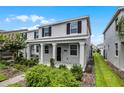 Beautiful home exterior with gray paint, black shutters and decorative landscaping at 3124 Addison Blvd, St Cloud, FL 34771