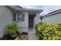 Inviting home entrance, complemented by lush plants and colorful shrubs at 3202 Timber Hawk Cir, Ocoee, FL 34761