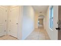 Bright hallway with tile flooring, arched doorway, and neutral color palette at 3202 Timber Hawk Cir, Ocoee, FL 34761