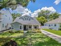 Charming craftsman home with lush lawn, landscaping, and a concrete driveway leading to the property at 3226 Helen Ave, Orlando, FL 32804