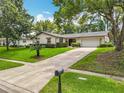Beautiful home with a well-maintained lawn, mature trees, and an expansive driveway leading to the garage at 404 Broadview Ave, Altamonte Springs, FL 32701