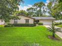 Charming single-story home with a manicured lawn, driveway, lush landscaping and a two-car garage at 404 Broadview Ave, Altamonte Springs, FL 32701