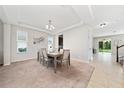 Inviting dining room with tray ceiling, neutral tones, and backyard views at 4952 Longmeadow Park St, Orlando, FL 32811