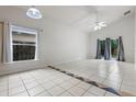 Well-lit living room with tile flooring, a ceiling fan, and sliding doors to the backyard at 5559 Pats Pt, Winter Park, FL 32792