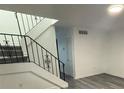 An interior staircase features stylish railings, hardwood floors, and new paint at 5930 Village Cir # Ge, Orlando, FL 32822