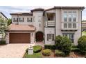 Beautiful two-story home featuring a tile roof, a turret entrance, and meticulously maintained landscaping at 682 Canopy Estates Dr, Winter Garden, FL 34787