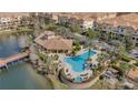 Community pool with a clubhouse, spa, surrounding palm trees, and a lake for resident enjoyment at 813 Greybull Run, Lake Mary, FL 32746