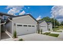 Close-up view of townhome exteriors, highlighting the attached garages and well-maintained landscaping at 8584 Magnificent Ln, Groveland, FL 34736