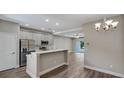 Open-concept kitchen featuring stainless steel appliances, a breakfast bar, and modern cabinetry at 8584 Magnificent Ln, Groveland, FL 34736