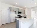 Bright kitchen with white quartz countertops, gray cabinets, and stainless steel appliances at 9112 Wildlight Trl, Wildwood, FL 34785