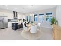 Modern kitchen and dining area with sleek countertops, stainless steel appliances, and stylish seating at the island at 10322 Marconi Ave, Orlando, FL 32827