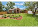 Single story brick home with a well-maintained lawn and garden at 109 Hunter Point Ct, Debary, FL 32713