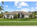Beautiful single Gathering home exhibits lush landscaping with a well-manicured lawn at 1301 Johns Cove Ln, Oakland, FL 34787