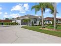 View of home with a two car garage, well-manicured lawn, and meticulous landscaping at 1301 Johns Cove Ln, Oakland, FL 34787