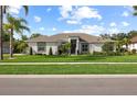 Single Gathering home exhibits a well-manicured lawn, complemented by palm trees and lush landscaping at 1301 Johns Cove Ln, Oakland, FL 34787