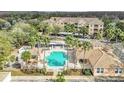 Beautiful aerial view of community pool with palm trees, clubhouse and condo building in a lush setting at 13512 Turtle Marsh Loop # 729, Orlando, FL 32837
