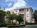 Condo exterior with balconies, manicured shrubs, and a view of a light colored three-story building at 13512 Turtle Marsh Loop # 729, Orlando, FL 32837