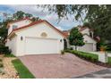 Lovely home with brick driveway, two-car garage, and a charming red tile roof at 1364 Augusta National Blvd, Winter Springs, FL 32708