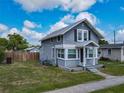 Charming two-story home featuring a covered entryway, gray siding, manicured lawn and a fenced backyard at 1504 Indiana Ave, St Cloud, FL 34769