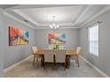 Formal dining room featuring tray ceilings, chandelier and neutral color palette at 1597 Katie Cv, Sanford, FL 32771