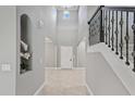 Grand foyer with soaring ceilings, decorative staircase and elegant tile flooring at 1597 Katie Cv, Sanford, FL 32771