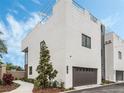 Modern home featuring a white exterior, two-car garage, roof deck, and manicured landscaping at 1760 Mondrian Cir, Winter Park, FL 32789