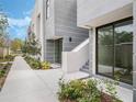 Exterior view of modern townhouses with gray siding, landscaped sidewalk, and contemporary architectural details at 1760 Mondrian Cir, Winter Park, FL 32789