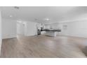Open-concept living area with tile flooring, seamlessly connects to a modern kitchen, creating an inviting space at 1812 Stoneywood Way, Apopka, FL 32712
