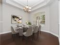 Formal dining room featuring a modern chandelier, large window, and seating for eight at 19562 Majestic St, Orlando, FL 32833