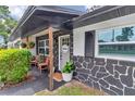 Cozy front porch with seating, decorative accents, and a 'Welcome' sign on the gray front door at 2105 Ne 50Th Pl, Ocala, FL 34479