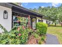 Inviting front porch with hanging plants, stone accents, and a 'Welcome' sign on the gray front door at 2105 Ne 50Th Pl, Ocala, FL 34479